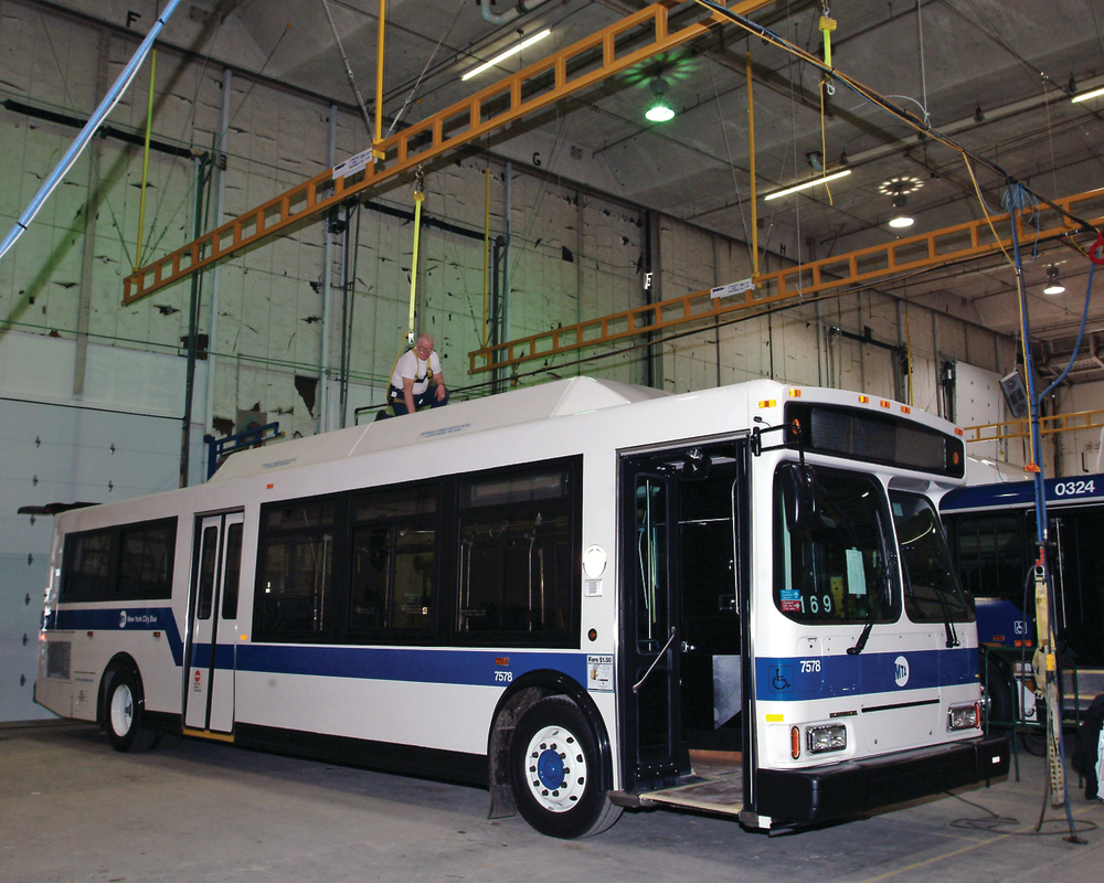 Rigid track with SRL provides fall protection safety for mass transit workers by reducing total fall distance from deflection and extension.