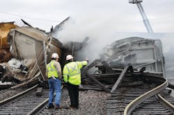 Workers survey the scene of devastation just hours after a CN freight train derailed near Bartlett, wrecking the intersection between the CN and Metra and trapping most of the Milwaukee West line fleet in its overnight storage yard.
