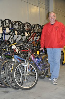 Firefighter Doug Smith, with several of the bikes to be donated in the COTA bus garage, appreciates the partnership with COTA founded two years ago.