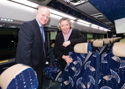 Canadian Member of Parliment Joyce Bateman and MCI Vice President of Operations Bryan Couch stand on one of the new coaches delivered to the government.