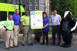 , Left to Right: Green Umbrella Executive Director Brewster Rhoads, Great Parks of Hamilton County Executive Director Jack Sutton, Cincinnati Parks Director Willie F. Carden Jr., Metro CEO Terry Garcia Crews, CRC Recreation Director Christopher Bigham and the Cincinnati Parks skunk critter helped unveil the new parks bus stop sign on July 10 in Cincinnati&apos;s Washington Park.
