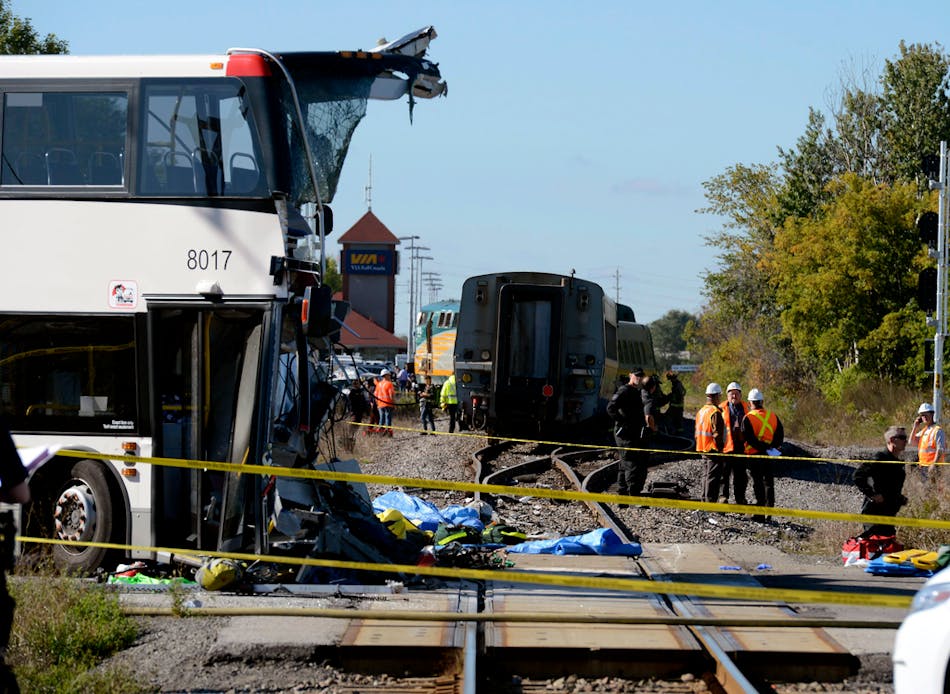 Emergency personnel look over the crash scene following a collision between a Via Rail train and a city bus at a crossing in Ottawa, Ontario, Wednesday, Sept. 18, 2013. An Ottawa Fire spokesman said there are &ldquo;multiple fatalities&rdquo; and a number of people injured from the bus. (AP Photo/The Canadian Press, Adrian Wyld)