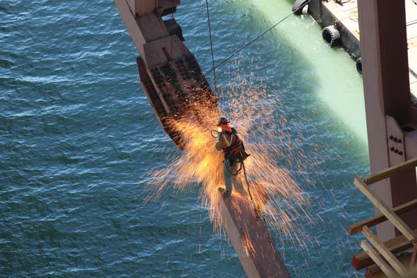 California Department of Transportation Engineer Martin Chandrawinata's photograph of an iron worker using a cutting torch while suspended from the San Francisco-Oakland Bay Bridge.