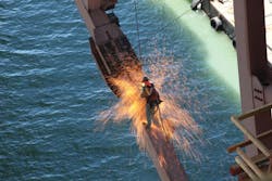 California Department of Transportation Engineer Martin Chandrawinata&apos;s photograph of an iron worker using a cutting torch while suspended from the San Francisco-Oakland Bay Bridge.