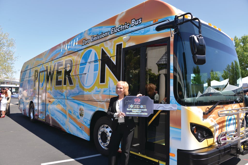 AVTA Executive Director Julie Austin holds the symbolic keys to the agency&apos;s new BYD electric bus, which features the new slogan &apos;Power On.&apos;