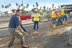 Mayor Greg Stanton assists with placement of the first track.