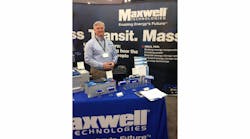 Chuck Cook, sales application engineer, Maxwell Technologies, in front of several of their ultracapacitor technologies on display at APTA 2014.