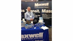 Chuck Cook, sales application engineer, Maxwell Technologies, in front of several of their ultracapacitor technologies on display at APTA 2014.