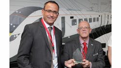 Keith Jordan of Hitachi Rail Europe, right, presents Patrick Riederer of Huber+Suhner with the Hitachi Supplier Award. Keith Jordan of Hitachi Rail Europe, right, presents Patrick Riederer of Huber+Suhner with the Hitachi Supplier Award.