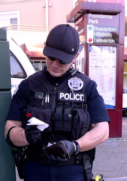 A TriMet officer looks through a wallet