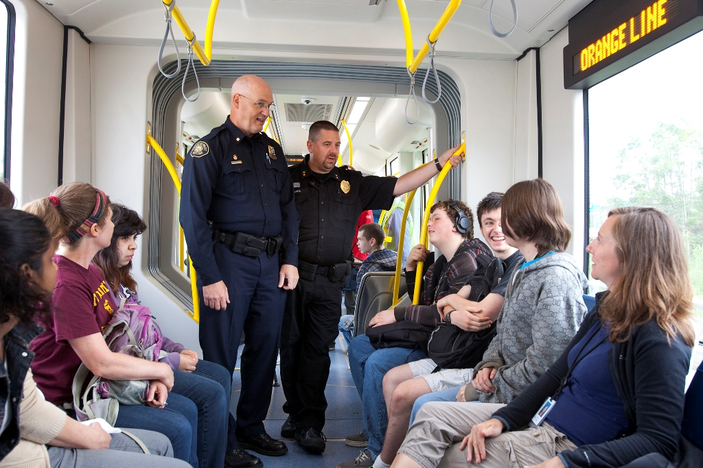 Transit Police Commander Mike Leloff, left, and Milwaukie Police Chief Steve Bartol, right, talk with students about the MAX Orange Line and safe behavior around trains.