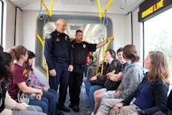Transit Police Commander Mike Leloff, left, and Milwaukie Police Chief Steve Bartol, right, talk with students about the MAX Orange Line and safe behavior around trains.