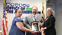 MTA Administrator Paul Comfort displays the Gold Award for Safety that MTA earned from the American Public Transportation Association for the agency’s Safety Rules and Compliance Program (SRCP), designed to keep customers, employees and equipment safe. MTA's Bernadette Bridges, head of the Office of Safety, Quality Assurance and Risk Management shares in the honor, left, assisted by Transportation Planning consultant Kimiya Rae Aghevli Darrell, right. MTA Administrator Paul Comfort displays the Gold Award for Safety that MTA earned from the American Public Transportation Association for the agency’s Safety Rules and Compliance Program (SRCP), designed to keep customers, employees and equipment safe. MTA's Bernadette Bridges, head of the Office of Safety, Quality Assurance and Risk Management shares in the honor, left, assisted by Transportation Planning consultant Kimiya Rae Aghevli Darrell, right.