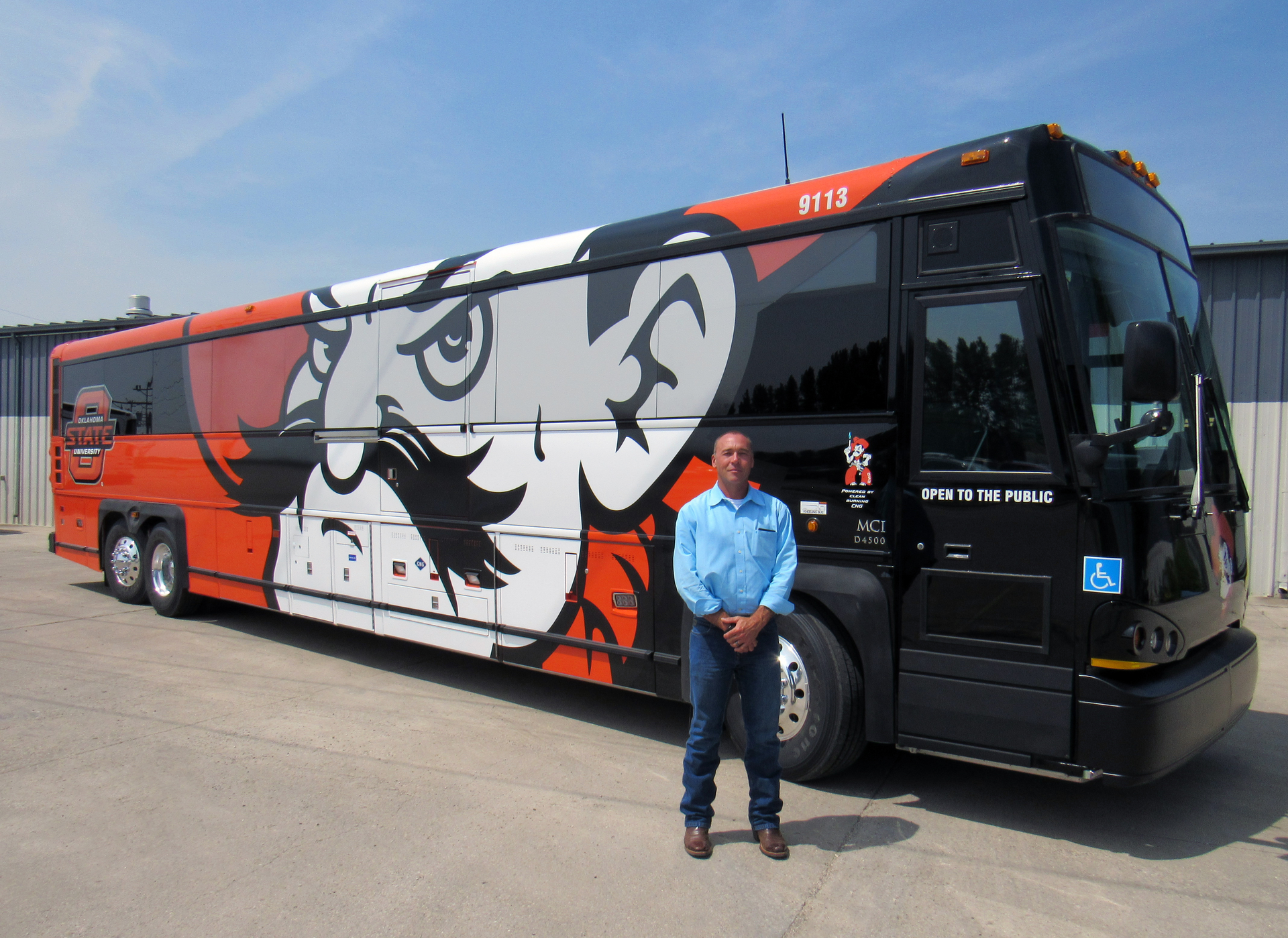 Oklahoma State University Transit Services Manager Tom Duncan with one of three new MCI D4500 coaches powered by CNG.
