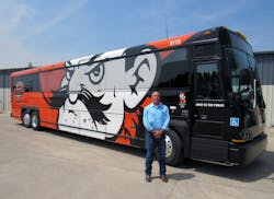 Oklahoma State University Transit Services Manager Tom Duncan with one of three new MCI D4500 coaches powered by CNG.