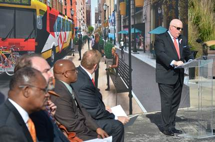 Maryland Governor Larry Hogan stands in front of a transitway backdrop as he outlines his $135 million plan to transform transit in Baltimore.
