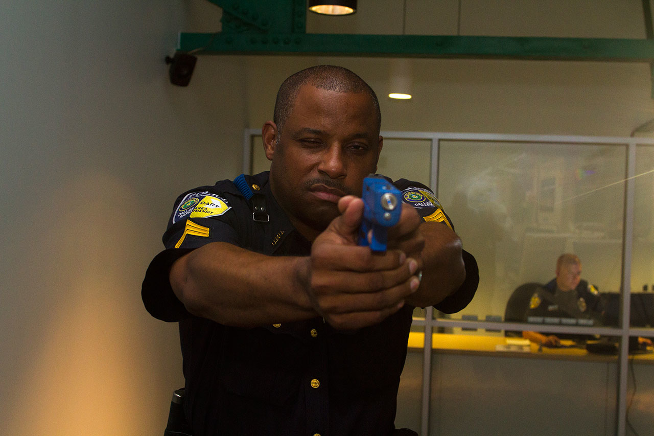 DART Police Sergeant Donovon Collins aims at a suspect in the use-of-force simulator.