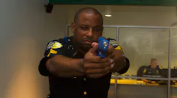 DART Police Sergeant Donovon Collins aims at a suspect in the use-of-force simulator.
