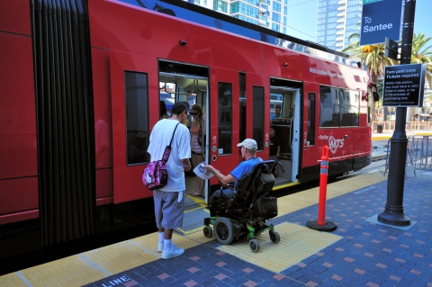 Unidentified Trolley passenger using a mobility device while boarding the Green Line Trolley to Santee.