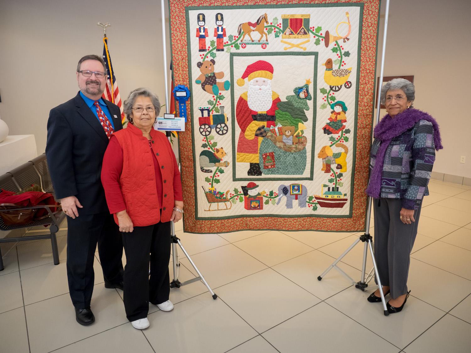 Carmen Zapata (r.), 1st Place in Fibers Craft at the Bravo for ArtAbility exhibit on display in The Grand at VIA Villa, is joined by VIA President/CEO Jeffrey C. Arndt (l.) and her friend, Tillie Gonzalez, at the reception for the exhibit.