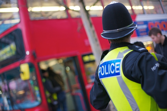 A West Midlands Police officer at a bus stop.