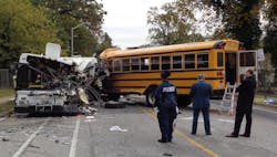 The final position of the transit bus and school bus. The school bus first impacted a passenger vehicle before crossing the center lane and colliding with the transit bus.