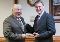 Brookville CEO and Chairman Dalph McNeil (left) passes the symbolic gavel to President Rick Graham.