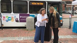 Denise Beck at an event showing someone how to use the transit tracker app.