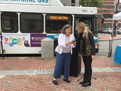Denise Beck at an event showing someone how to use the transit tracker app.