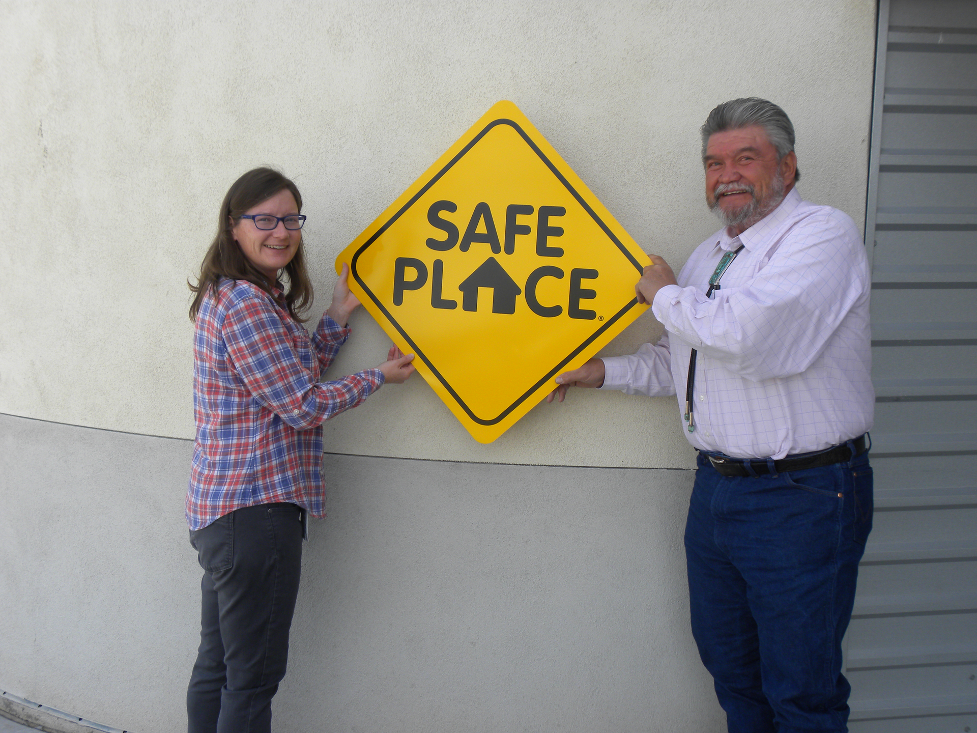 NCRTD Chair and Town of Taos Mayor, Daniel Barrone (R), and Stacey McGuire (L), NCRTD Planning, Projects & Grants Manager, display a copy of the Safe Place sign that has been placed on the RTD fleet of buses.