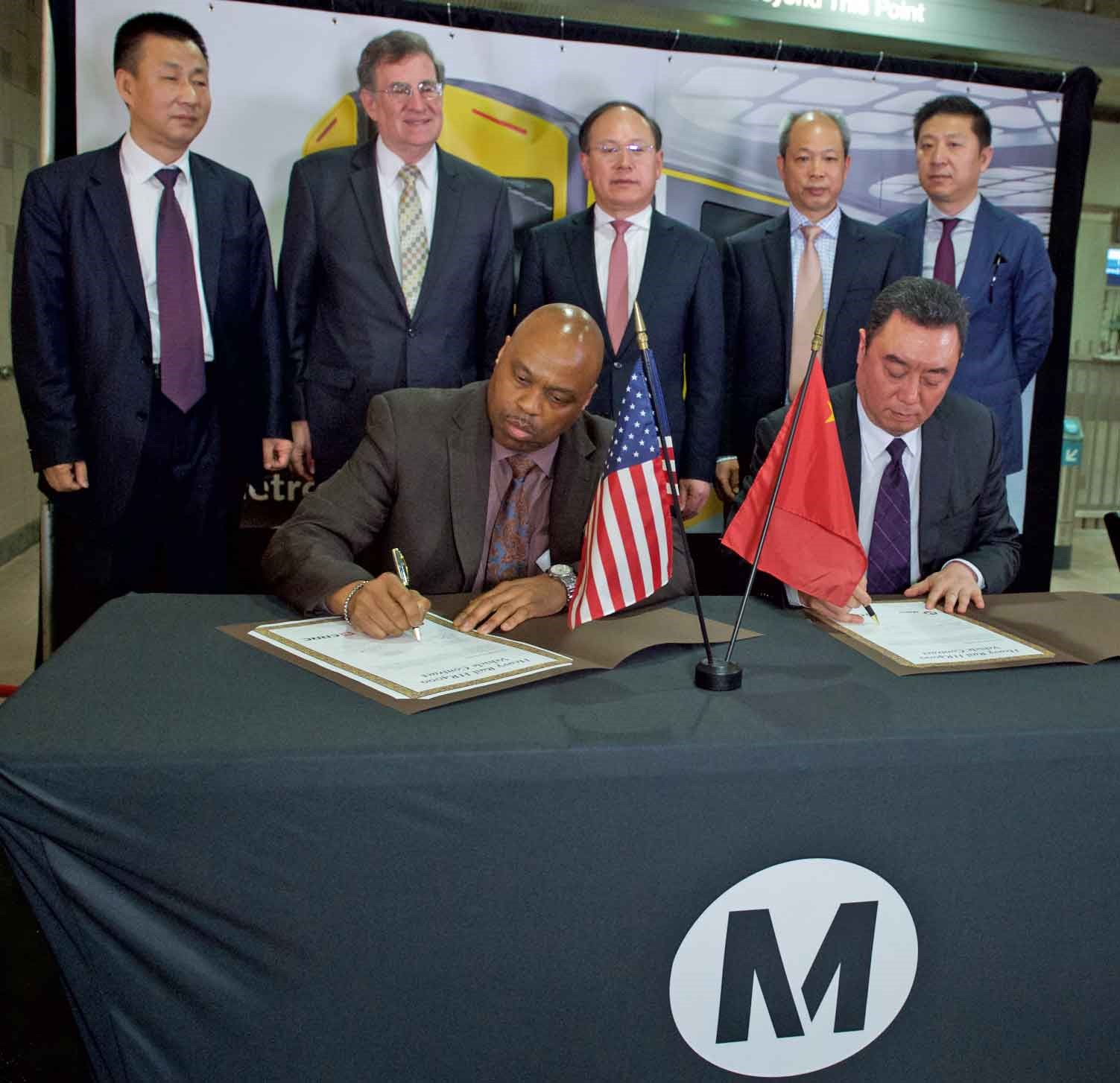 Front Row: Phillip A. Washington, Metro CEO and Chuanhe Zhou, CRRC MA president sign new Metro Red/Purple Line rail car contract. Back Row: Zhongyi An, general manager, CRRC Changchun; Guohua Xi, president, CRRC; Wang Jun, vice president, CRRC; Jia Bo, vice president, CRRC MA.