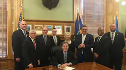 Kansas Gov. Sam Brownback (center) signs House Bill 2096 into law. Also in attendance are Paul Snider (KCATA), Sen. Mike Petersen (Chair of the Transportation Committee), Tuck Duncan (Kansas Public Transit Association), Josh Powers (Johnson County, Kan.), Sen. Pat Pettey (Ranking minority member of Transportation Committee), Robbie Makinen (KCATA), Sam Desue (KCATA), and Cory Davis (KDOT).