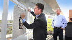 The signing of a commemorative plaque marks the start of construction on the 50th St/Washington Valley Metro Rail station. Phoenix Mayor Greg Stanton adds his signature to the plaque, which will be incorporated into the new station, as the owner of Stockyards Restaurant and Jokake Real Estate Services Gary Smith looks on.