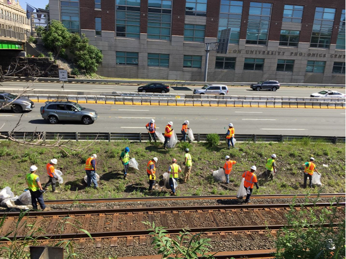 Crews collect trash between the Framingham/Worcester Line and the Massachusetts Turnpike.
