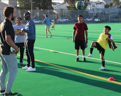 Isai Catalan (in yellow) kicks a soccer ball at practice while SF Deltas players look on. Isai Catalan (in yellow) kicks a soccer ball at practice while SF Deltas players look on.