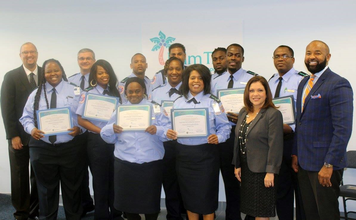 On the left, Director of Operations Sean Smith, and on the right, Assistant County Administrator Nancy Bolton and Executive Director Clinton B. Forbes gather alongside Palm Tran&rsquo;s newest bus operator graduates.