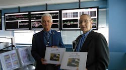Both versions of the map books being turned over to Acting General Manager Joseph Tassiello (on left) by PTSI Transportation Managing Director Michael Weinman.
