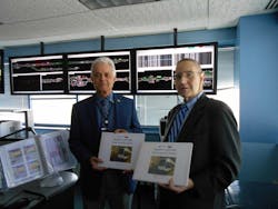Both versions of the map books being turned over to Acting General Manager Joseph Tassiello (on left) by PTSI Transportation Managing Director Michael Weinman.