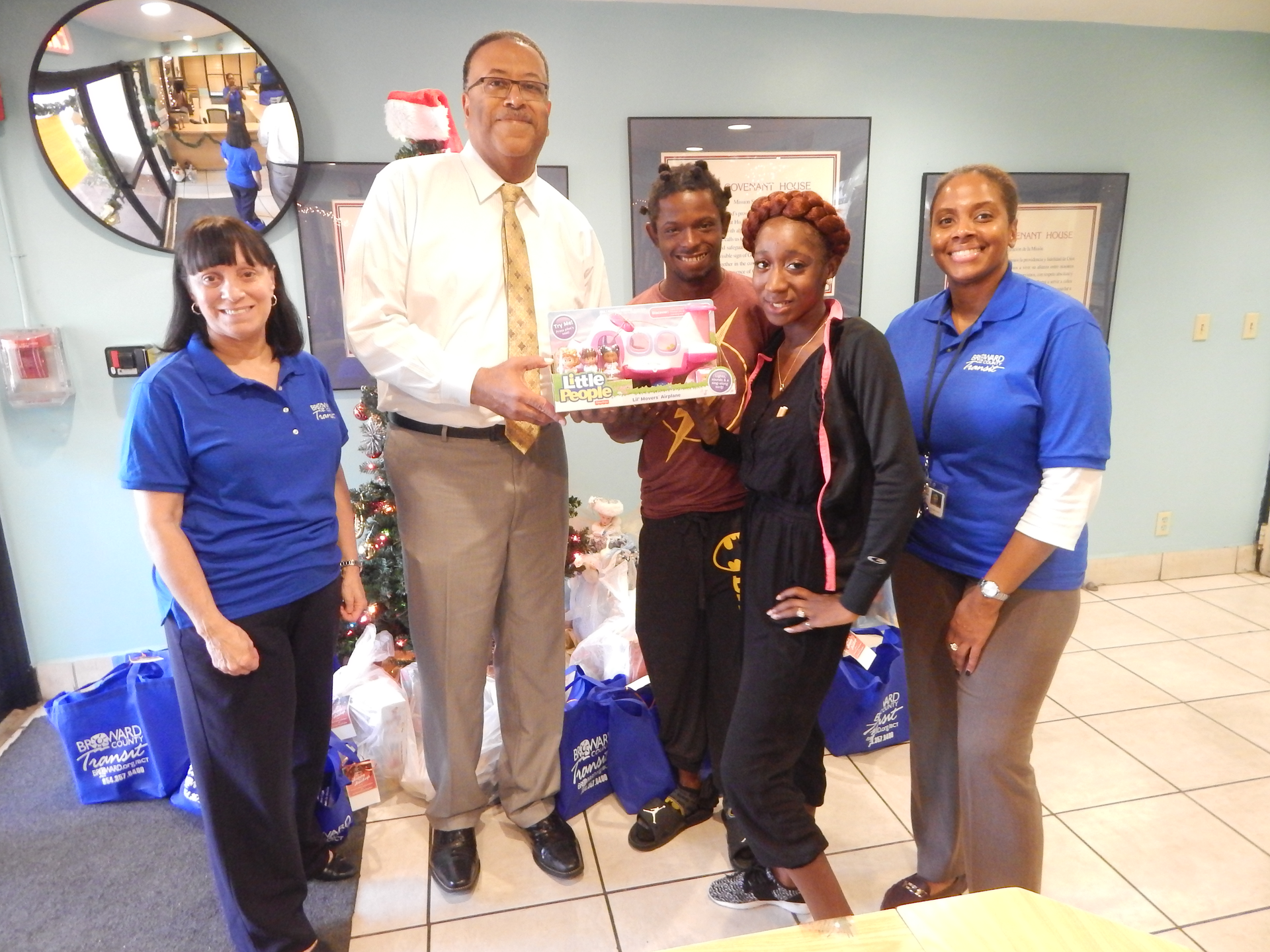 County Transportation Director Chris Walton presents Covenant House residents who are parents of a toddler, with one of the donated items collected through the BCT 2nd Annual Toy Drive.
