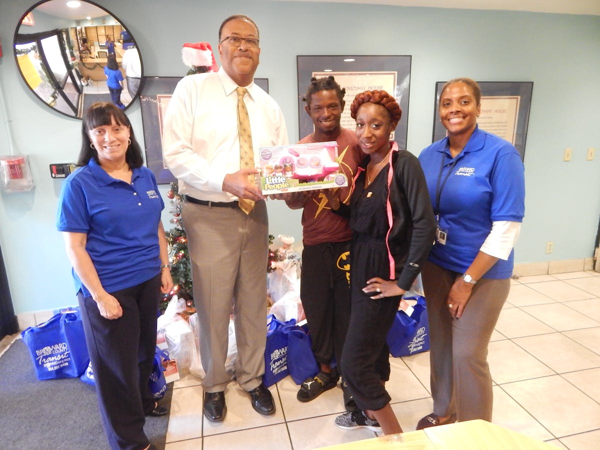 County Transportation Director Chris Walton presents Covenant House residents who are parents of a toddler, with one of the donated items collected through the BCT 2nd Annual Toy Drive.