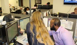 Palm Tran Executive Director Clinton B. Forbes receives guidance from seasoned agents as he answers calls in Palm Tran&rsquo;s fixed-route customer service department.