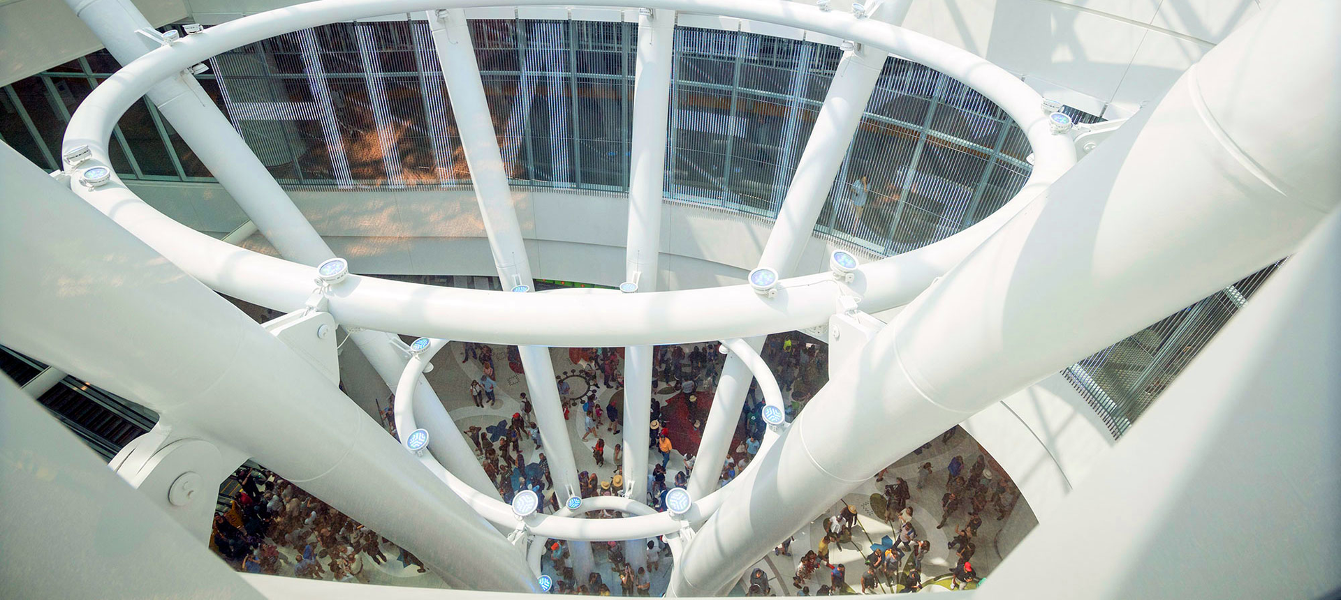 A four-story elliptical oculus skylight is encircled by an 180-foot-long LED screen displaying scrolling digital text, an installation by artist Jenny Holzer.