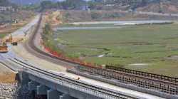 The completed concrete bridge with double track construction occuring in the background can be seen in this photo of the San Elijo Lagoon Double Track Project.