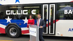 Cummins Vice President-Electrified Power Julie Furber. left, and GILLIG President and CEO Derek Maunus speak to a crowd at the APTA 2019 Mobility Conference in front of GILLIG&apos;s new battery electric bus.