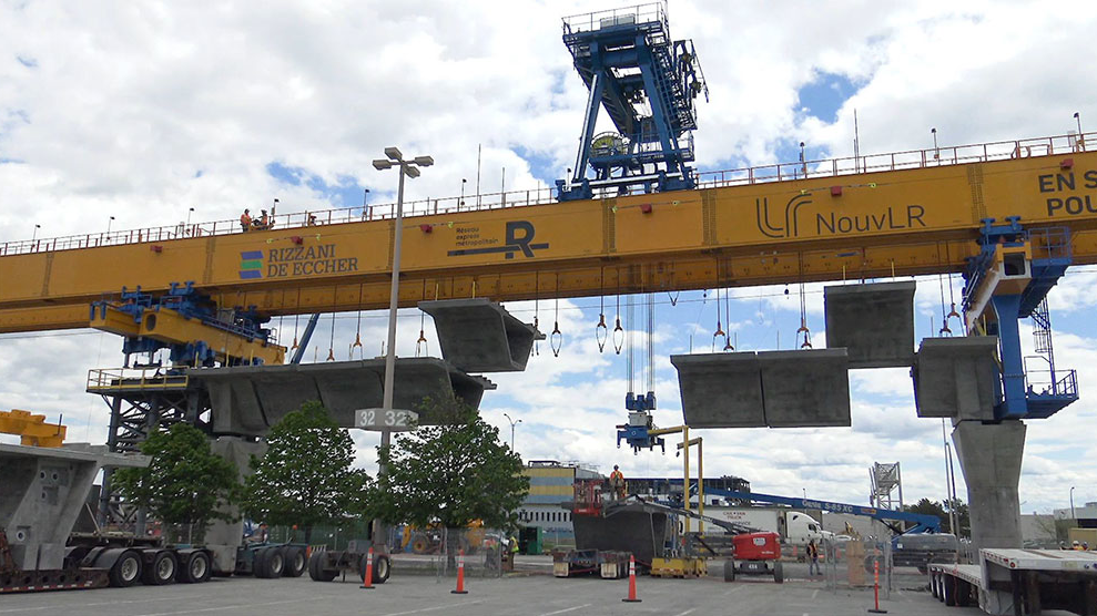 A launching gantry with several prefabricated concrete segments ready for assembly.