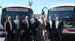 SEPTA officials and industry partners stand in front of two of the transit authority's new battery electric buses at the Southern Bus Depot.