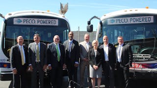 SEPTA officials and industry partners stand in front of two of the transit authority&apos;s new battery electric buses at the Southern Bus Depot.