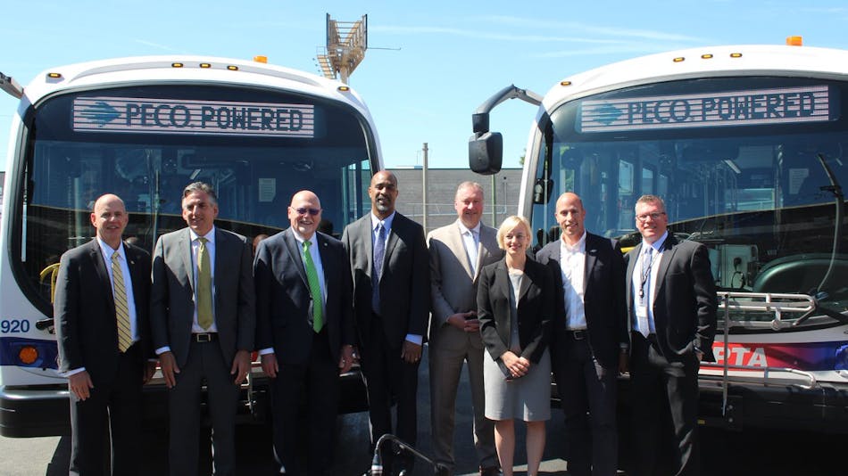 SEPTA officials and industry partners stand in front of two of the transit authority&apos;s new battery electric buses at the Southern Bus Depot.