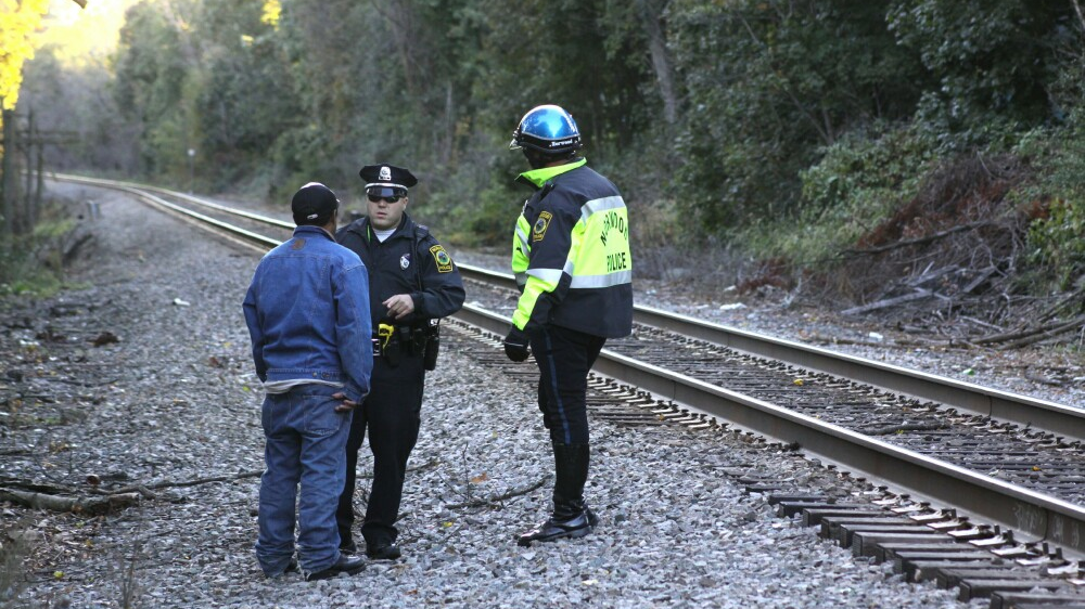 File photo from 2012 shows an MBTA police officer and an officer from a local jurisdiction speaking with a trespasser on the MBTA Franklin Line.