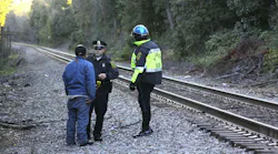 File photo from 2012 shows an MBTA police officer and an officer from a local jurisdiction speaking with a trespasser on the MBTA Franklin Line.